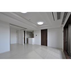 中古マンションをリフォームして新居にとお考えだったK様。以前のキッチンやLDKの床は、ダークブラウン系の木目柄でやや暗い印象だったため、ホワイト・ライト系の素材に取替えて、明るく清潔な空間に。L型の引き戸で仕切られていた和室は、リビングとフラットにつながる洋室へとリフォーム。今はオープンにしてリビングの一角として使用していますが、将来的に間仕切って子ども部屋として使えるように、廊下とつながる引き戸はそのまま残しています。