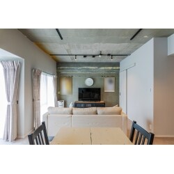 マンションの規約によりフローリングにすることができませんでしたので、カーペットを活かすコーディネートをご提案しました。スケルトンにして現しとなった壁と天井をカーペットの柔らかな質感と対比させ、それぞれの質感が際立つようにホワイトグレーの淡いトーンで色合いを押さえています。LDKに隣接していた和室を一体化することでおよそ18帖大となったリビングダイニングは天井高も最大限にあげられ、とても明るく心地よい空間となりました。