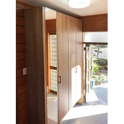 既存収納におさまらず、2倍以上の大きさに収納を交換。底板がないタイプにしたので、傘や灯油のタンクが扉内に収まるようになりすっきりした玄関内になりました。