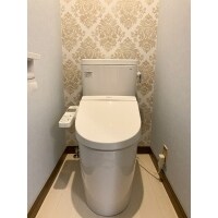 アクセントウォールとラウンドタンクのトイレで優しい印象に