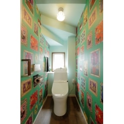 奥様が一目ぼれした、ナタリー・レテのデザインクロスを使用したトイレ。手洗いの高さは使いやすく、掃除もしやすくなった。壁の絵を引き立てる為、正面と天井は淡い水色に。紙巻き器とタオル掛けはアイアン製。