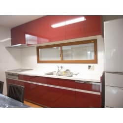 LIXIL製のシエラでキッチン本体・カップボード・家電収納を統一。キッチンの扉はディープレッドで存在感をカップボードと家電収納庫の扉はホワイトで清潔感と空間の広さを演出しました。