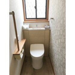 シンプルな空間から、おしゃれな花柄のアクセントクロスが映える空間に。キャビネットにはトイレットペーパーや掃除用具など、トイレにあふれがちな小物を収納できます。