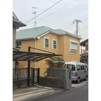 オリーブグリーンの屋根とやまぶき色の外壁塗装で明るい外観に