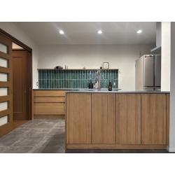 ステンレス天板のシャープさと、無垢材のぬくもりが心地よく調和するキッチン。使い込むほどに味わいが増し、カップボード背面のタイルがアクセントになっています。