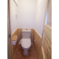 天然木のドアと腰壁でナチュラルテイストなトイレに