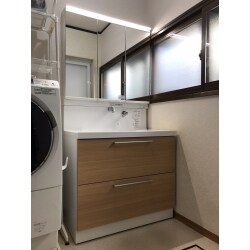 排水に問題が生じ、浴室リフォーム工事の後でしたがタイミングよく即工事に入ることができました。キャンペーン中ということもあり、除菌水付きで奥様もお喜びです。顔の近くまで引き出せる三面鏡なので、お嬢様のメイクにも活躍しそうな化粧台です。ＬＥＤ照明もスッキリと見やすく設置されています。