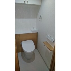 お施主様からのご相談は、「湿っぽく、暗い感じがするマンションのトイレを、爽やかな明るいトイレにしたい！」ということでした。トイレを拝見すると、一般的なマンションの大きさのトイレでした。しかし、大きな吊戸があったため、それが原因で圧迫感があります。収納としてこの吊戸は残しつつ、広々と見せるためにはどうしたらいいか考え、キャビネット付きのトイレをご提案しました。