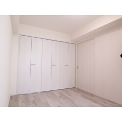 リビングに隣接した６畳の和室。
押入れと横並びの床の間を撤去して、全面クローゼットへ変更。Panasonic製 木目のホワイトオーク柄のフローリング、ドアはホワイトアッシュ柄を統一しました。白いクロスで清潔感漂う洋室へ、グレイッシュな淡い空間へ生まれ変わりました。