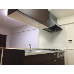 間取りはそのままでシステムキッチンを新しく入れ替えました。ダークブラウンの木目色は、白く明るい内装の中でひと際落ち着いた雰囲気で引き締まります。