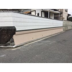 お家の広い敷地を囲う塀の一部は大谷石（おおやいし）が積まれています。経年劣化で風化して表面がボロボロに崩れていました。今回はコスト面を考えて表面にモルタルを塗り、塗装仕上げをしました。