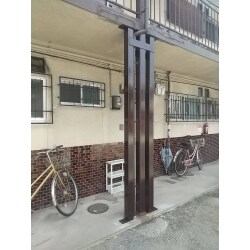 経年と雨水侵食で傷みの激しいアパート外部通路柱補修後、両サイドに鉄骨補助柱を建てて補強しました。