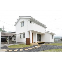 広い土地にはアプローチから庭へと芝生が敷かれ、新緑に漆喰の白い壁が鮮やかに映える。まるで絵本に出てきそうなファンシーな住まいは奥様のこだわりを実現しました。