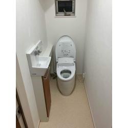 1階と2階に2つトイレがあり、2階のトイレは先に別の業者様によってリフォーム済みで、今回は1階のトイレをご希望でした。2階のトイレの施工で給水配管が表に出てしまったことから、1階は表に見えない仕様で、手洗い器つきのトイレにしたいとのことでした。また、剥げているのが気になっていたドアのハンドルも新しいものに交換しました。