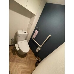 トイレは向かって右側が壁に隣接しており、左レバーのタイプが設置していました。新しいトイレも同じ左レバーのタイプの物を発注し、LIXIL「アメージュ便器」の真っ白なトイレは清潔感たっぷりです。施主様の希望だったヘリンボーン柄の床に、当社からご提案させていただいたダークカラーのアクセントクロスでとてもおしゃれなトイレ空間ができあがりました。