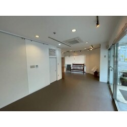 こちらの店舗はこれまで倉庫のような形でお使いで、お客様を招き入れられるよう内装リフォームを施工することになりました。店内に広がる荷物を別の場所に移動させてから工事はスタート。壁と天井の塗り替え、床の張り替え、古くなった水まわりの交換、間取り変更を行いました。
壁と天井は内装用の塗料を使って白く塗り替えました。床は「長尺シート」と呼ばれるシート状の床材を張ります。ビフォーで同一空間にあったトイレと簡易キッチンは別々の空間に分けてお客様が使いやすいように変更します。トイレは和式から洋式へ交換、簡易キッチンも新しく取り替えました。