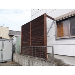 玄関前の風の通りがよく、強風対策に防風壁を設置いたしました。木製のフェンスで仕上げており、外観のイメージを崩さないデザインです。