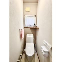 設備も内装もスマートに。グレージュのアクセント壁が光るトイレ