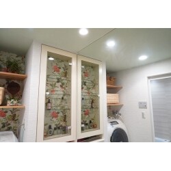 天井まである一面鏡が特徴的な洗面室なので鏡の反射を活かしてお部屋の印象をより明るくするようにご提案し、壁一面をアクセントクロスで白を基調とした冷たい雰囲気から緑豊かな暖かい印象のお部屋をご案内しました。