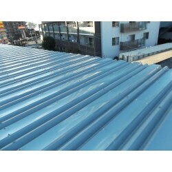 倉庫や工場などでよくある折板屋根の場合、積雪の後雨が降った時勾配が少ないため雪が雨水の流れを止めてしまい屋根の重なりから雨水が侵入し雨漏りになるケースが2014年の大雪と雨で多く発生しました。弊社では板金加工できる技術を利用し重なり部分に雪が積もらない様、フタをする仕組みをつくり加工した板金を取り付けることにより水があふれても雪のないところを水が通るので雨漏りを防ぐことができます。
他では既存の屋根にもう一度同様の屋根を葺くやり方をしますがこの方法だとコストを大幅にカットすることができます。