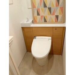 収納付きトイレを取付、トイレ背面にエコカラットを配して明るいイメージになりました。