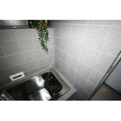 壁は２００ｍｍ角の御影、床は１００ｍｍ角の御影、ステンレス浴槽とシルバーの水栓、シャワーヘッドで統一感を出しています。