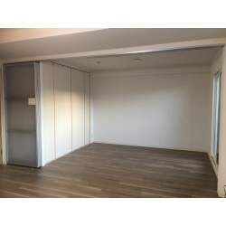 和室を解体し、リビングとつながる洋室へリフォームしました。リビングと旧和室は同一の内装材で仕上げ、間仕切りには圧迫感のない、アルミ吊戸を設置いたしました。