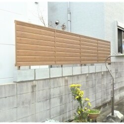 LIXILの横ルーバーの木目調フェンスで、色も綺麗なチェリーウッドを選ばれました。天然木のような風合いのアルミ形材パネルで表裏に曲線を施し、目隠しと通風を両立させたデザインです。
既存塀にケミカルアンカー打設し一段ブロックを積みフェンスを設置させていただきました。
また、樋の取替施工もさせていただきました。
