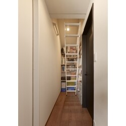 ロフトに上がるための梯子スペースをご家族共有の収納として有効活用しています。収納棚は用途によって高さを変えられるようにしました。
