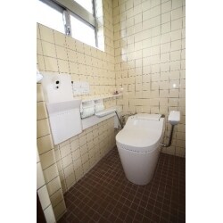 現状でも壁に手すりなどは付いているのですが、トイレ本体に手すりが付いているのはこのトイレだけの特別オプションです。「そもそもトイレの横に手すりは必要？」と思われるかもしれませんが、機会があったらショウルームに行って、実際に座ってみてください。とても「楽」に感じると思われます。ちょうど「肘掛け付きのイス」に座っている感じになります。健常者にも「楽」に感じるということは、お年寄りなどの方にはなおさらです。さらに「麻痺」などがあって身体に不自由をお感じになる方には、手すりに肘を乗この手すりは上下に可動しますので、お掃除も簡単。たいへんおすすめの商品です。