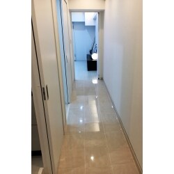 光輝く白い床が、お部屋へのアプローチ。高級感のある明るい廊下になりました。