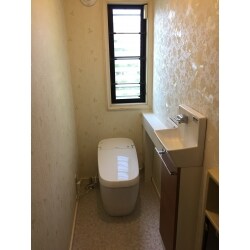 重厚感のある「サティスG」へリフォーム致しました。
 壁紙は、右手に大柄の花模様のアクセントクロスを施工。周囲のクロスは植物ということで、同系統のクローバーをあしらったクロスにしました。
 毎日が楽しくなる華やかなトイレ空間となりました。