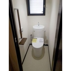 高齢の両親の為に手すりを付けた、白がベースの明るいトイレ