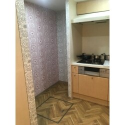 サンゲツのカタログの中にある柄の一つで北欧フィンランドで有名なメーカーの「フィンレイソン」のクラシックデザイン壁紙を選びました。同じ柄を２種類の色見で施工したので明るく、華やかなキッチン空間に仕上がりました。また、床はクッションフロアー（塩ビシート）なのですが、ヘリンボーン調でかっこよくオシャレに仕上がっております。冷蔵庫等の移動があり大変でしたが、素敵に仕上がりお客様も満足してくださいました。
