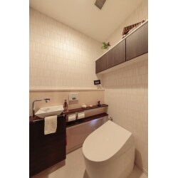 独立した手洗器をご希望でしたので、タンクレスのトイレと、独立した手洗器を取り付けることができる「ワンデーリモデル」をおすすめすることに。
既存のトイレ空間は、奥行きが短く横幅が広いタイプだったので、ワンデーリモデルの既定の幅に合わせるために手洗器側の壁を「ふかす（壁の仕上げ面を前に出す）」こと、更に水撥ねに強く掃除のしやすいセラールにて仕上げることをご提案しました。