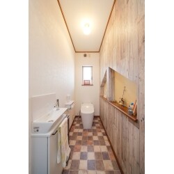 ダメージ感のある板壁調クロスがアクセント壁になり、アンティーク調の床との相性は抜群。
トイレもタンクレスのシンプルなものに取り替えて、手洗いカウンターを新設しました。
