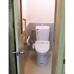 和式トイレ→洋式トイレになる事を踏まえ、壁のタイル部分には掃除のしやすいパネルを使用。洋式への変更に伴い、あわせて手すりも設置。