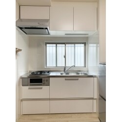 古くなったキッチンを、明るい色のシステムキッチンに取り替えました。床の色も明るい白の木目柄に変わりました。