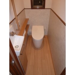 築30年のトイレをリフォーム。床をタイルから掃除しやすいクッションフロアに替え、壁もクロスに貼り替え明るくなりました。照明器具は消し忘れを防止する自動センサー付きとし、出入り口の敷居を無くし段差を解消しました。在来の便器は使用後に流す水の量が13Ｌなので、大の時3.8Ｌで流せる超節水型便器に交換。