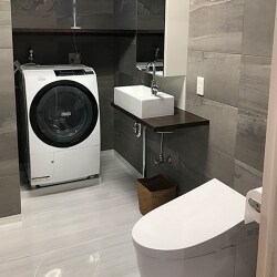 壁にエコカラット、床にはハイドロセラを使用したトイレ一体のサニタリールームへリフォーム！両方を石目調にすることで高級感のあるカッコいい空間に変わりました。