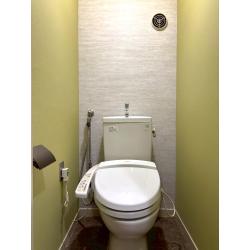 クロスとクッションフロア、紙巻器を替えてトイレをイメージチェンジ！背面のテクスチャー壁と重厚感ある紙巻器が洗練されたグレード感をプラスしています。