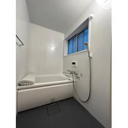 バランス釜を壁貫通型給湯器へ変更し、浴槽を広げた明るく清掃しやすい浴室です。