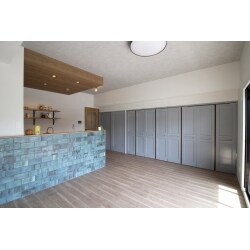 キッチンの垂れ壁は撤去し開放感のある空間に。キッチンの天井は下がり天井だったので、あえてそこにアクセントクロスを使用することで、ワンポイントになりました。キッチンの腰壁にはタイルを使用。デザイン性のある味のあるタイルなので、目を引きます。LDKの建具も取替え、隣接する建具はグレーに塗装。よりカフェにいるような雰囲気に仕上がりました。