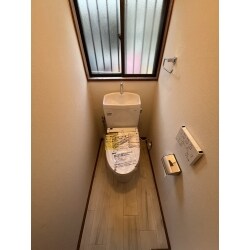白を基調といたしました空間のお色味とフローリングにて、ナチュラルで美しいトイレ空間になりました。リモコンが壁付になりましたことで空間にゆとりができましたように感じられます。