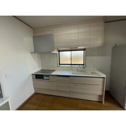 LIXILノクト(W２５５０)をチョイスしました。吊戸の高さはH700を設置し一つは、電動で収納が下りてくるオートダウンウォールを採用しました。このキッチンはシンクの幅が900ミリもあるのが特徴です。左側の壁と天井も部分的にクロス補修を行いました。クロスが新しくなると広く感じますね。