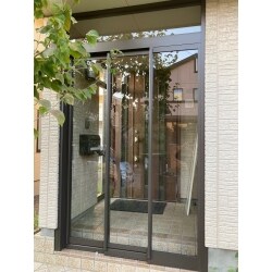 リクシル　ツインガード3　袖付き二枚引きにて、風除室を施工させていただきました。
大開口とノンレールで出入りが楽々です。
既存の窓枠などとの色合いもマッチした広々エントランスルームが出来ました。