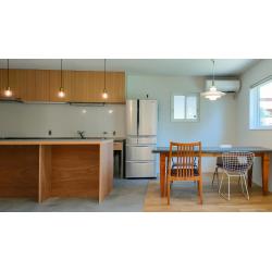 キッチンエリアにはグレーのフロアタイルを採用。リビング側のフローリングと素材を切り替えることで、間仕切り壁がなくても空間にメリハリを生んでいます。