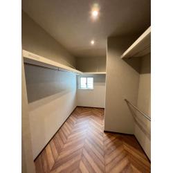 ヘリンボーンの床材が素敵なWIC。一部、ハンガー掛けを上下にセットし、丈の短い物やお子様のお洋服も掛けられるよう仕上げています。