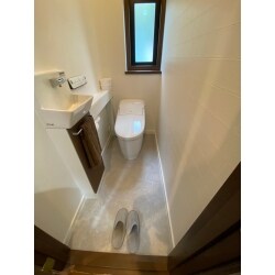 トイレは手洗い場がセットのモノを採用しました。白を基調とした空間にブラウンをプラス。シンプルでお掃除もしやすいトイレです。