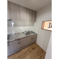 囲まれた空間に配置したキッチン。壁付なので上部に収納棚をつけても圧迫感ゼロ！小窓をつけて、リビングにいる家族ともコミュニケーションが取れるようにしました。